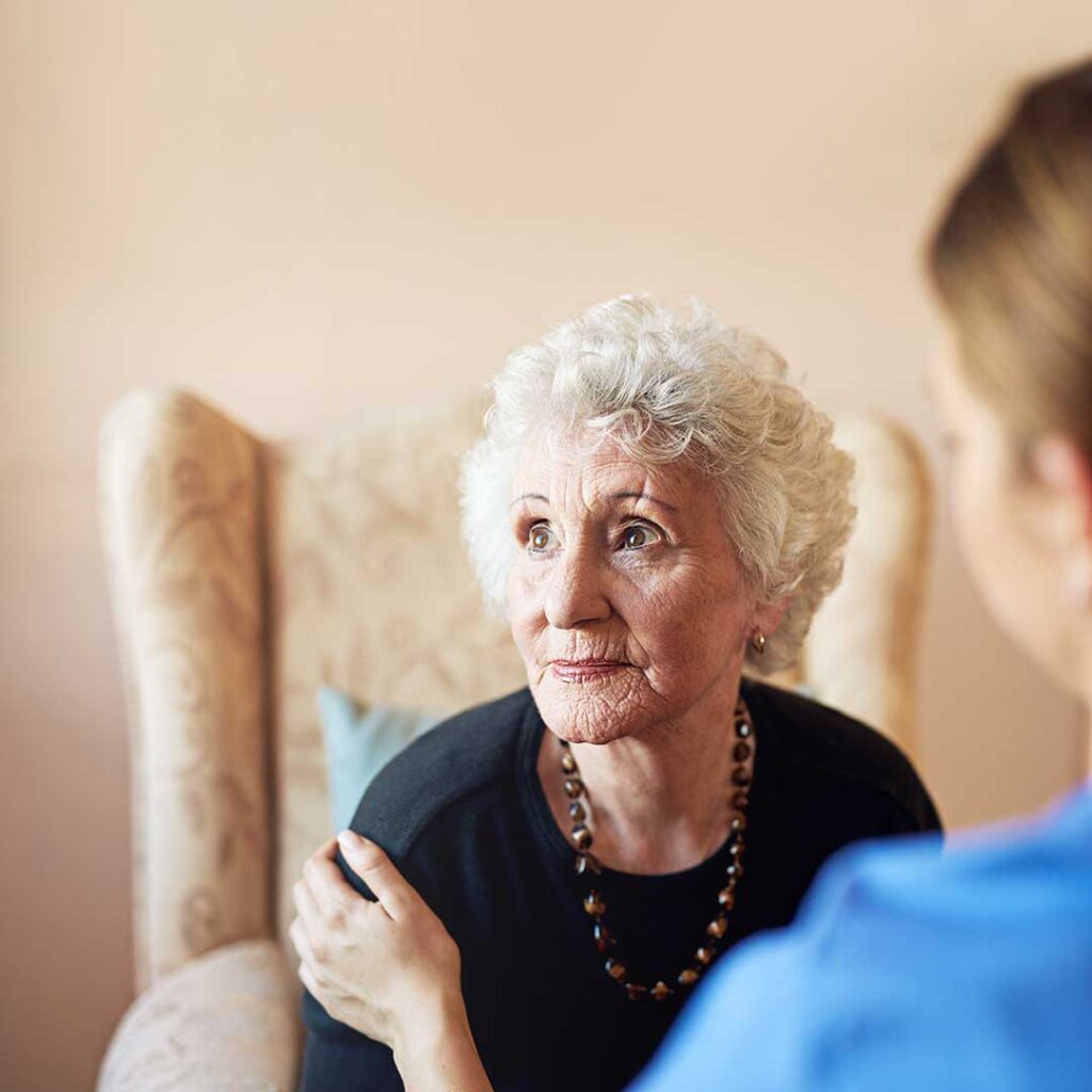 Older adult arranging personal belongings with family in a bright assisted living room